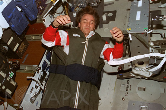 Astronaut asleep in the space shuttle Discovery