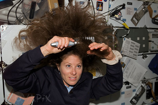 Tracy Caldwell brushing her hair in the space shuttle Endeavour