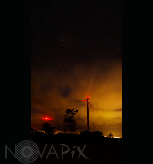 Ciel étoilé derrière les nuages et éoliennes
